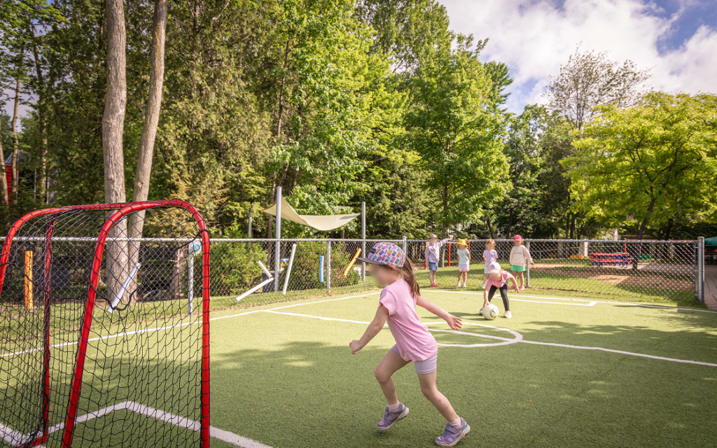 Des enfants jouent au soccer sur le terrain