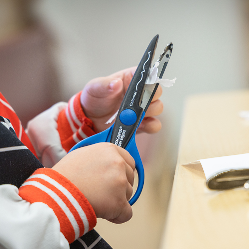Un enfant découpe une feuille de papier