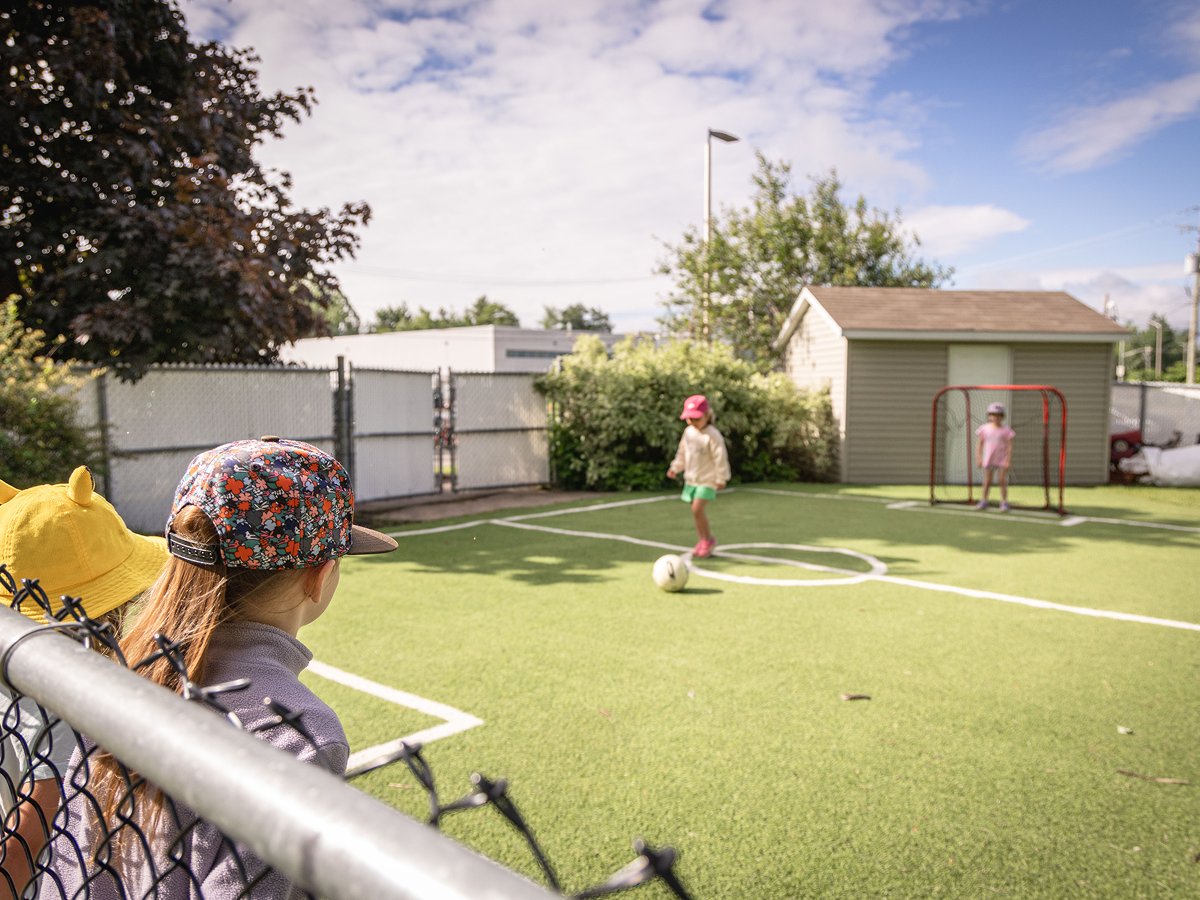Des enfants jouent au soccer sur le terrain